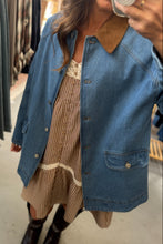 Load image into Gallery viewer, Person wearing a denim jacket over a striped dress in a store setting