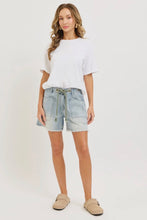 Load image into Gallery viewer, Woman wearing a white top and light blue denim shorts on a white background