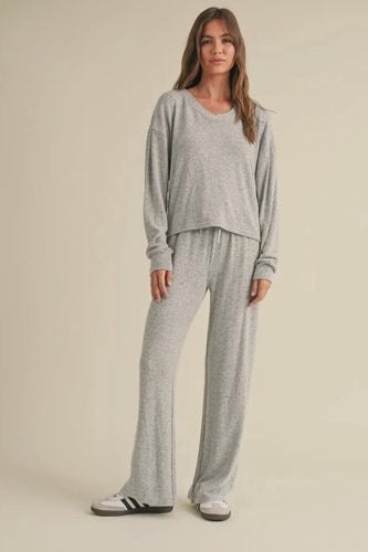 Woman wearing a gray loungewear set on a beige background
