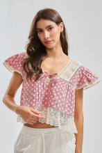 Load image into Gallery viewer, Woman wearing a red and white patterned top with lace details on a light gray background