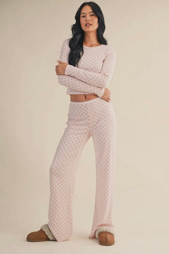 Woman wearing a polka dot pajama set on a beige background