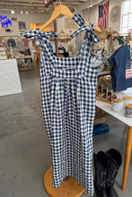 Load image into Gallery viewer, Black and white checkered dress on a hanger with a store interior background