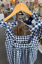 Load image into Gallery viewer, Navy and white checkered dress on a hanger with a blurred store background