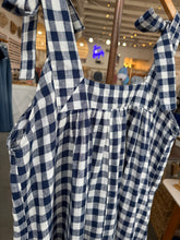 Load image into Gallery viewer, Blue and white checkered fabric draped over a chair with a blurred indoor background