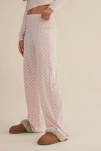 Load image into Gallery viewer, Person wearing a patterned outfit with brown slippers on a beige background