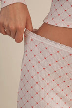 Load image into Gallery viewer, Close-up of a person wearing a patterned top and pants with a beige background