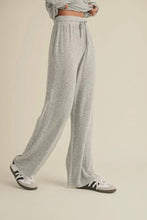 Load image into Gallery viewer, Person wearing gray sweatpants and Adidas sneakers on a beige background