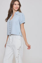 Load image into Gallery viewer, Woman wearing a light blue denim shirt and white pants on a plain background