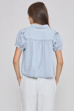 Load image into Gallery viewer, Light blue denim shirt worn by a person on a plain background
