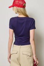 Load image into Gallery viewer, Person wearing a purple t-shirt and beige pants with a red cap on a plain background