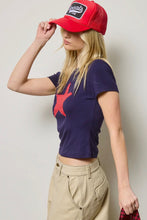 Load image into Gallery viewer, Person wearing a red cap and navy t-shirt with a star design against a plain background