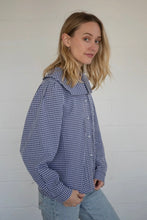 Load image into Gallery viewer, Woman wearing a blue checkered shirt against a white background