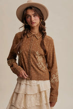 Load image into Gallery viewer, Woman wearing a brown embroidered blouse and beige hat against a neutral background