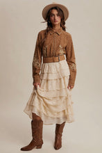 Load image into Gallery viewer, Woman wearing a patterned blouse, beige skirt, and brown boots with a beige hat on a neutral background