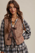 Load image into Gallery viewer, Woman wearing a plaid shirt, brown vest with a bow, and necklace against a neutral background