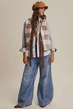 Load image into Gallery viewer, Woman wearing a plaid shirt, scarf, and jeans with a beige background