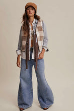 Load image into Gallery viewer, Woman wearing a plaid vest, denim jeans, and a cap on a beige background