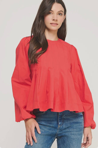 Woman wearing a red blouse and blue jeans on a white background