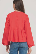 Load image into Gallery viewer, Person wearing a red blouse with puffed sleeves and blue jeans on a white background