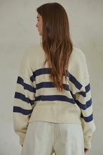 Load image into Gallery viewer, Woman wearing a cream sweater with navy stripes from behind on a neutral background