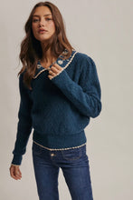 Load image into Gallery viewer, Woman wearing a blue sweater with decorative trim against a plain background