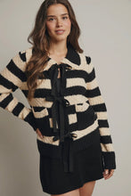Load image into Gallery viewer, Woman wearing a black and beige striped sweater with a bow tie on a plain background