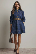 Load image into Gallery viewer, Woman wearing a denim dress with a belt, holding a brown handbag against a plain background