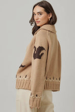 Load image into Gallery viewer, Woman wearing a beige knitted sweater with a pattern on a plain background