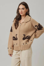 Load image into Gallery viewer, Woman wearing a beige sweater with black swan designs on a plain background