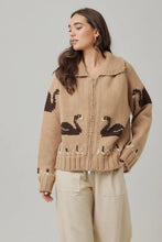 Load image into Gallery viewer, Woman wearing a beige sweater with black patterns on a plain background