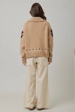Load image into Gallery viewer, Person wearing a beige cardigan with cut-out details on a plain background