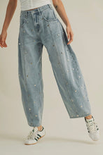 Load image into Gallery viewer, Light blue jeans with decorative studs worn by a person on a plain background
