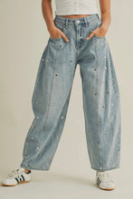 Load image into Gallery viewer, Light blue denim pants with decorative studs worn by a person on a beige background
