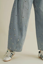 Load image into Gallery viewer, Light blue jeans with decorative studs worn by a person on a plain background