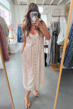 Load image into Gallery viewer, Woman taking a mirror selfie wearing a beige button-up dress in a clothing store.