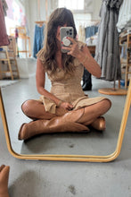 Load image into Gallery viewer, Woman sitting on the floor in a clothing store, wearing a dress and brown boots.