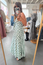 Load image into Gallery viewer, Person wearing a green checkered dress in a clothing store.