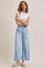 Load image into Gallery viewer, Woman wearing a white crop top and light blue jeans on a plain background
