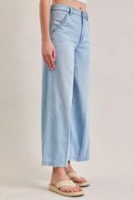 Load image into Gallery viewer, Light blue denim pants worn by a person on a beige background