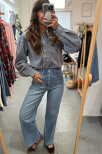 Load image into Gallery viewer, Person taking a mirror selfie wearing a checkered shirt and jeans in a clothing store.