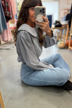 Load image into Gallery viewer, Woman taking a mirror selfie wearing a checkered shirt and jeans in a store.