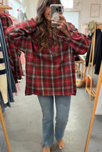 Load image into Gallery viewer, Person wearing a red plaid shirt and blue jeans in a clothing store.