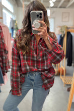 Load image into Gallery viewer, Person wearing a red plaid shirt and blue jeans in a clothing store.