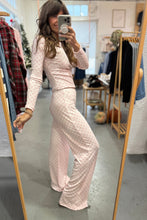 Load image into Gallery viewer, Woman taking a mirror selfie wearing a light pink polka dot outfit in a clothing store.