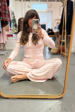 Load image into Gallery viewer, Woman taking a mirror selfie wearing pink pajamas in a room with clothes and furniture.