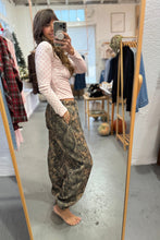 Load image into Gallery viewer, Person taking a mirror selfie wearing a light pink top and patterned pants in a clothing store.