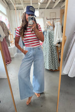 Load image into Gallery viewer, Person taking a mirror selfie wearing a red and white striped shirt, blue jeans, and a cap in a clothing store.