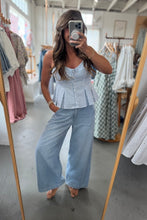 Load image into Gallery viewer, Woman taking a mirror selfie wearing a striped top and wide-leg pants in a clothing store.