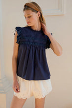 Load image into Gallery viewer, Woman wearing a navy blue top and white lace shorts indoors.