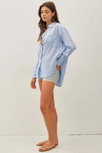 Load image into Gallery viewer, Woman wearing a light blue oversized shirt and gray shorts on a white background
